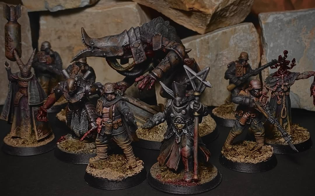 Grupo de miniaturas de warband herege em tons terrosos com detalhes de sangue e uma criatura central